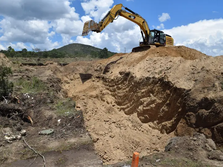 Excavadora sobre el bordo de una zanja