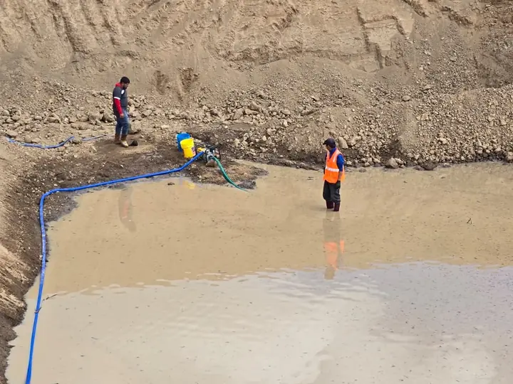Trabajadores dentro de un vaso con agua de lluvia